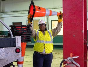 worker loading traffic cones on truck